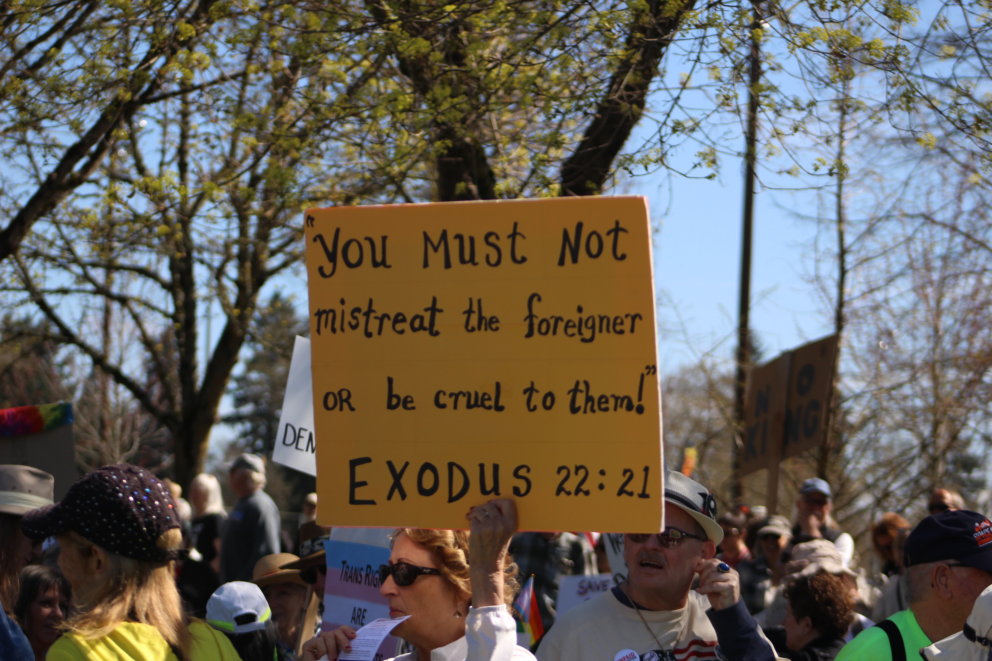 A protestor's sign reads "you must not mistreat the foreigner or be cruel to them!" (Will Legg / VanCougar)