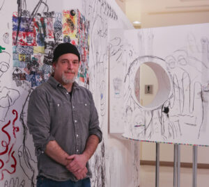 Artist Karl Burkheimer in front of his recent piece.