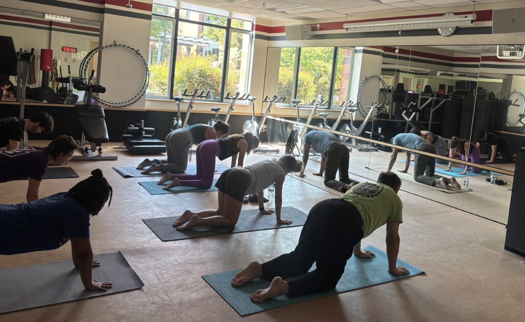 Class attendees and Nanu Iyer doing yoga in the fitness center at WSU Vancouver. (Elizabeth Flores/The VanCougar)